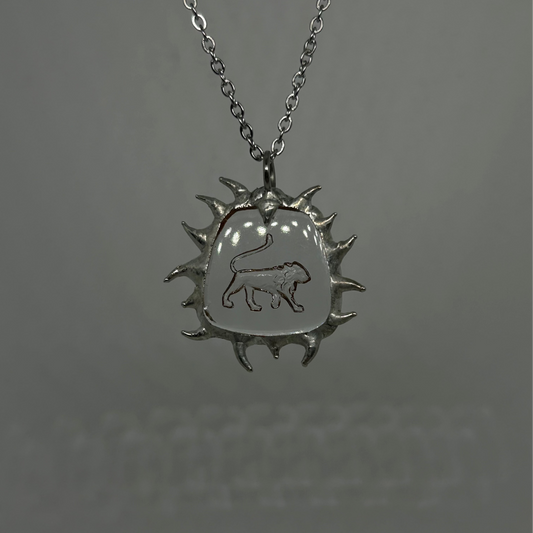 Silver necklace with a sun-shaped pendant featuring a lion emblem